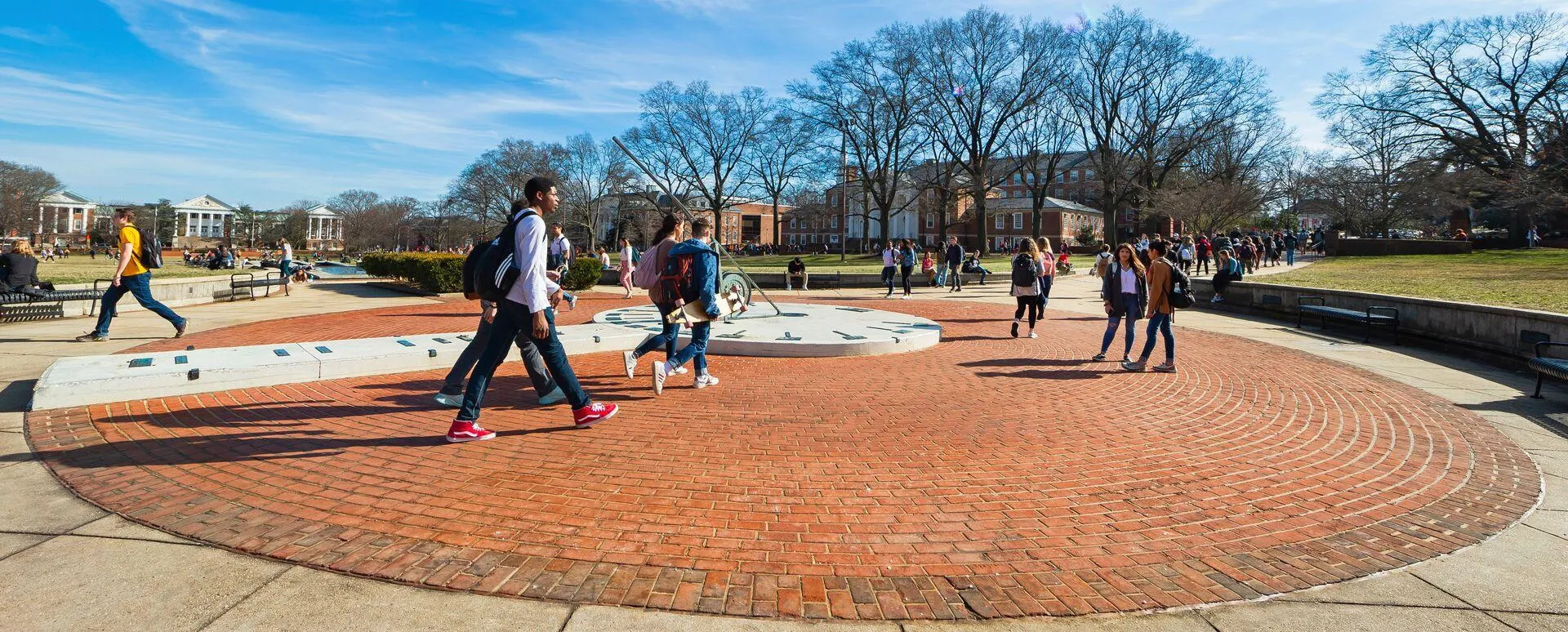 students walking around sundial