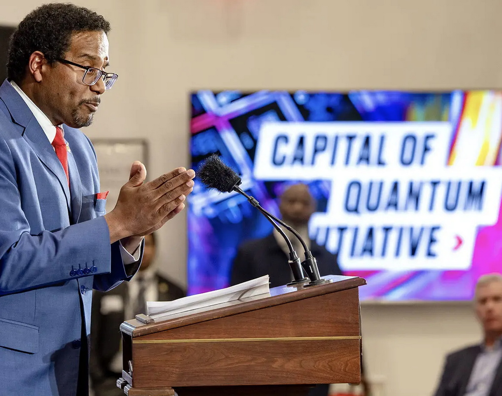 President Pines at podium announcing Capital of Quantum at IonQ.