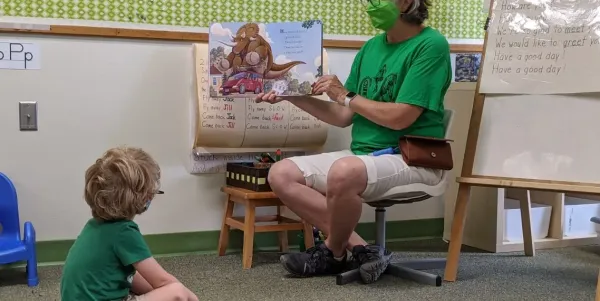 A CYC teacher reads a picture book aloud to a child