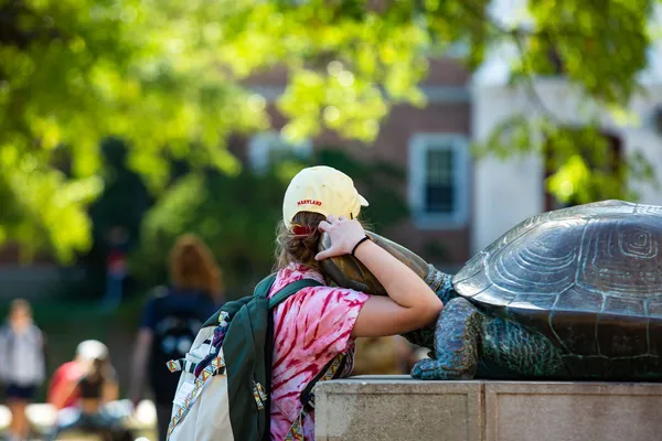 A student hugs the Testudo statue on McKeldin Mall